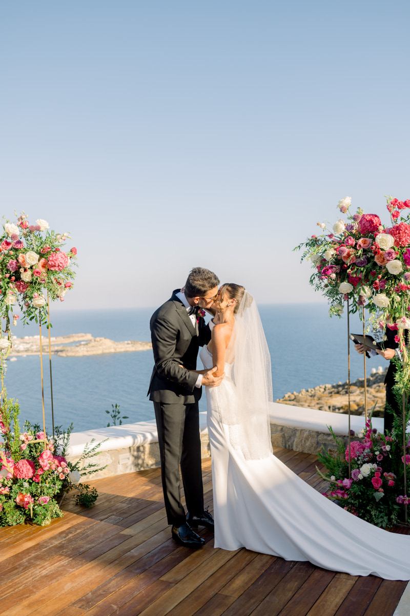 A professional photographer capturing a wedding ceremony in Mykonos, beautifully preserving precious moments.